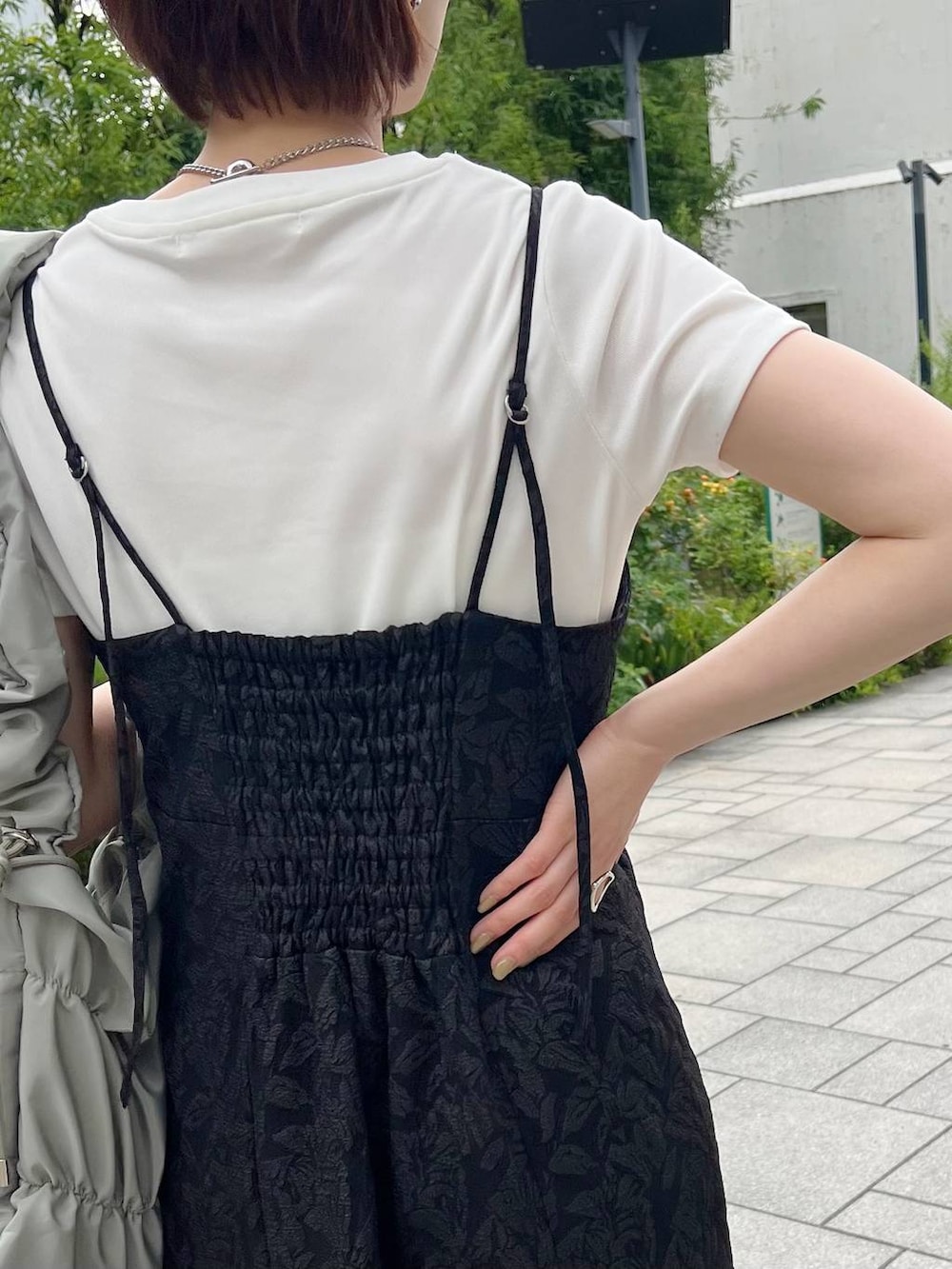 グリーン系のショルダーバッグ、ホワイト系のTシャツ/カットソー、ブラック系のサンダルを着用したレディースの夏コーディネートの4枚目の写真