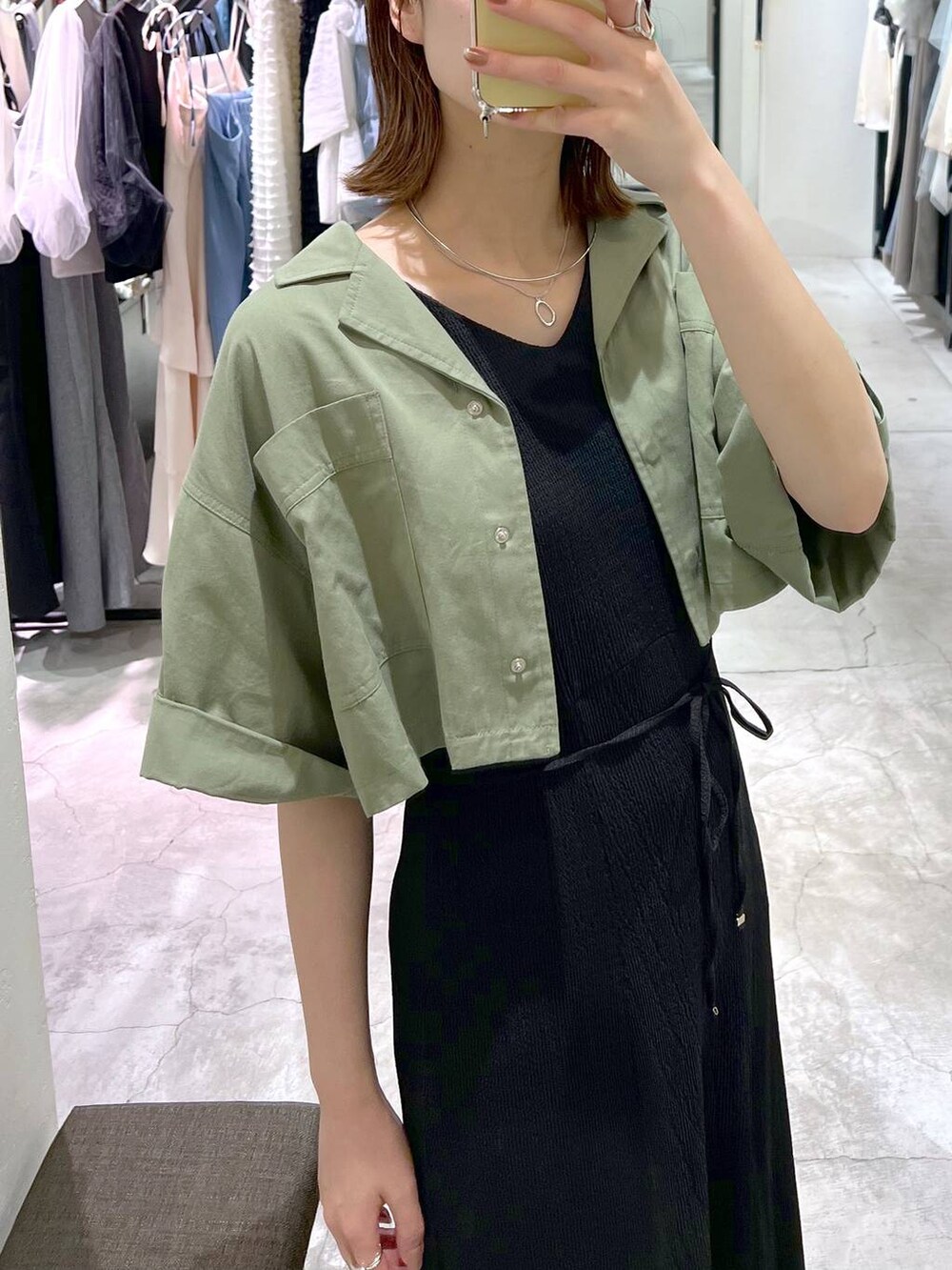 ブラック系のサンダル、シルバー系のハンドバッグ、グリーン系のミリタリージャケットを着用したレディースの夏コーディネートの6枚目の写真