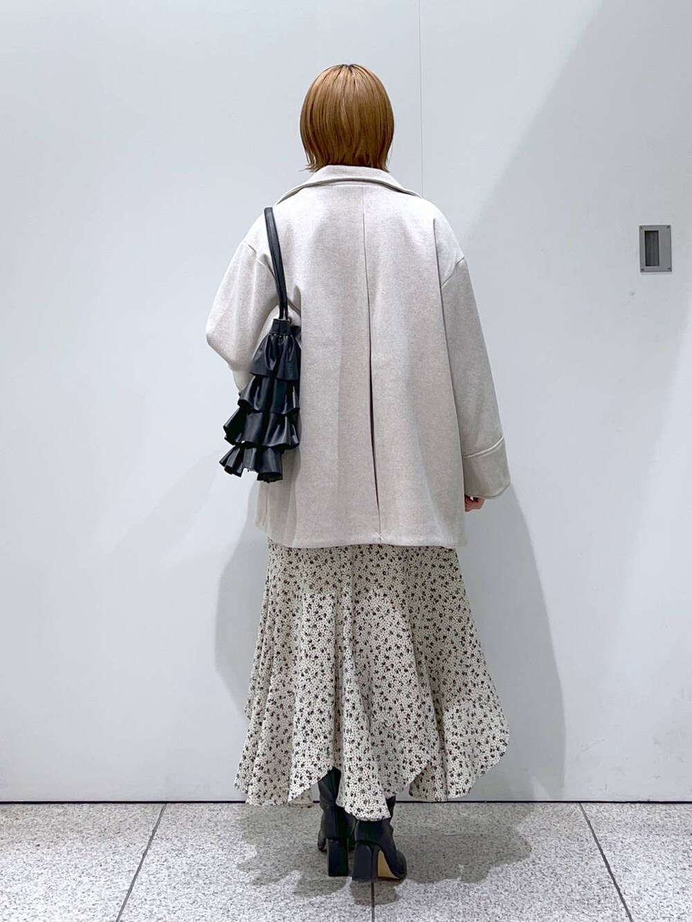 ブラック系のブーツ、ブルー系のニット/セーター、ホワイト系のスカートを着用したレディースの冬コーディネートの4枚目の写真