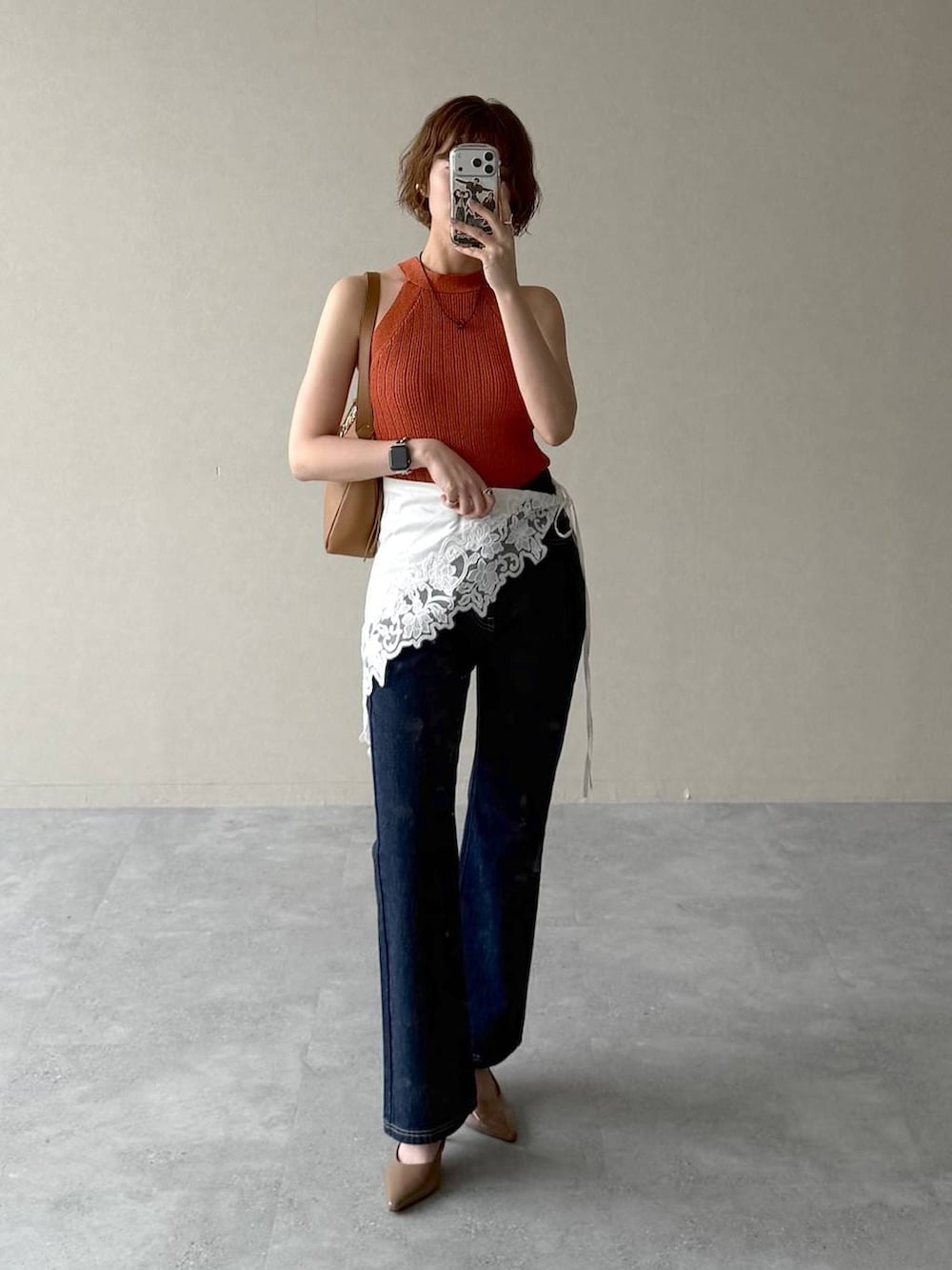 ブルー系のデニムパンツ、ブラウン系のサンダル、イエロー系のショルダーバッグを着用したレディースの春コーディネートの5枚目の写真