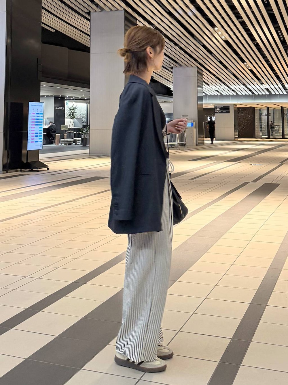 ブラック系のハンドバッグ、ブルー系のその他パンツ、ブルー系のテーラードジャケットを着用したレディースの春コーディネートの2枚目の写真