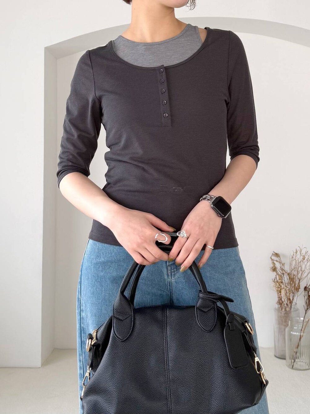 ブラック系のボストンバッグ、ブラック系のサンダル、ブルー系のデニムパンツを着用したレディースの春コーディネートの4枚目の写真