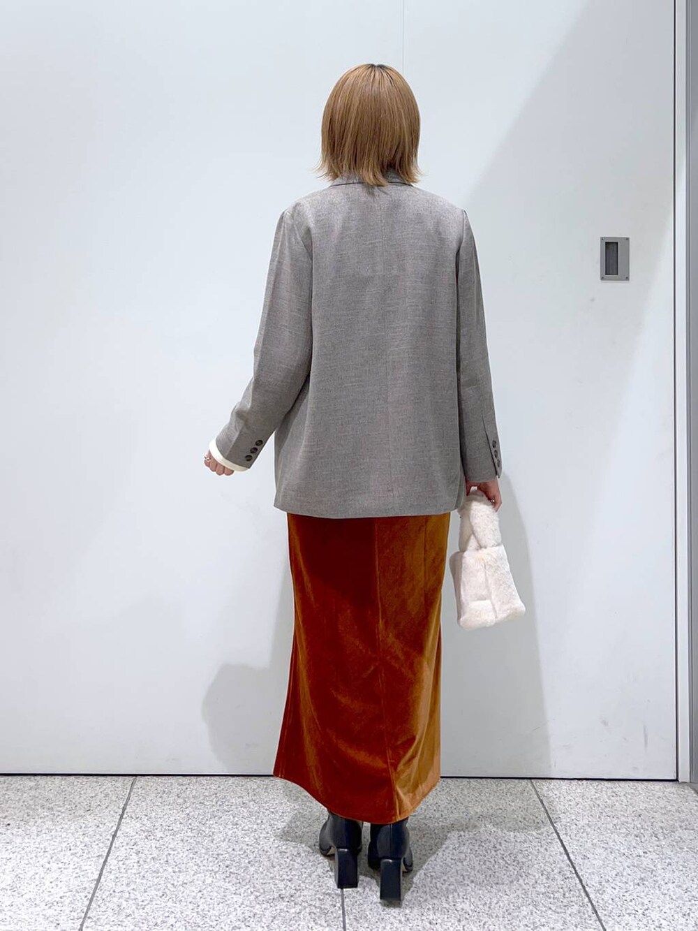 ホワイト系のTシャツ/カットソー、ブラック系のブーツ、グレー系のテーラードジャケットを着用したレディースの秋コーディネートの3枚目の写真