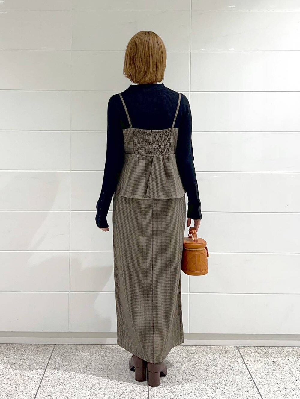 ブラウン系のブーツ、ブラウン系のワンピース、オレンジ系のショルダーバッグを着用したレディースの秋コーディネートの3枚目の写真