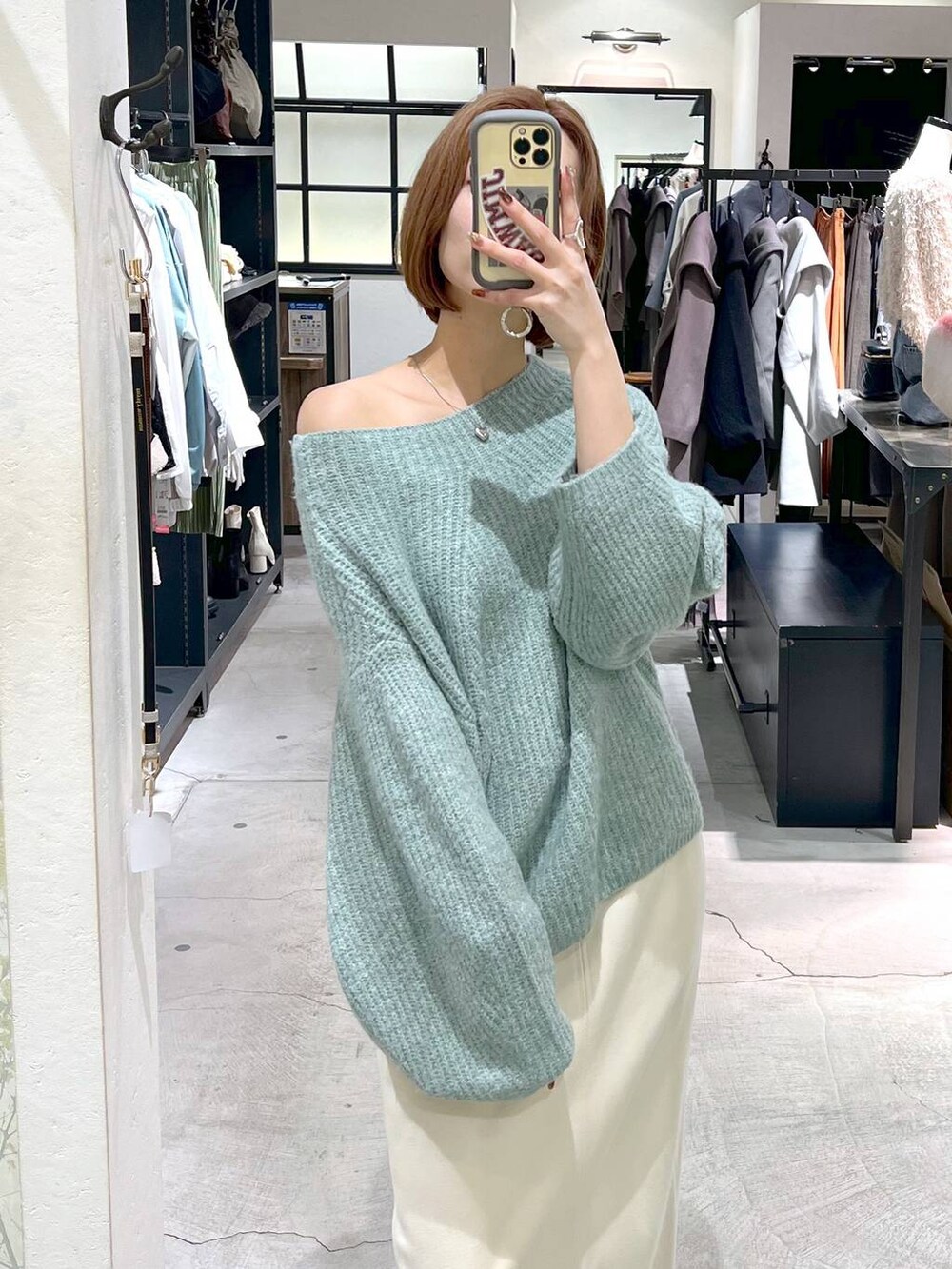 グレー系のノーカラーコート、ブラック系のショルダーバッグ、ブラック系のブーツを着用したレディースの秋コーディネートの9枚目の写真