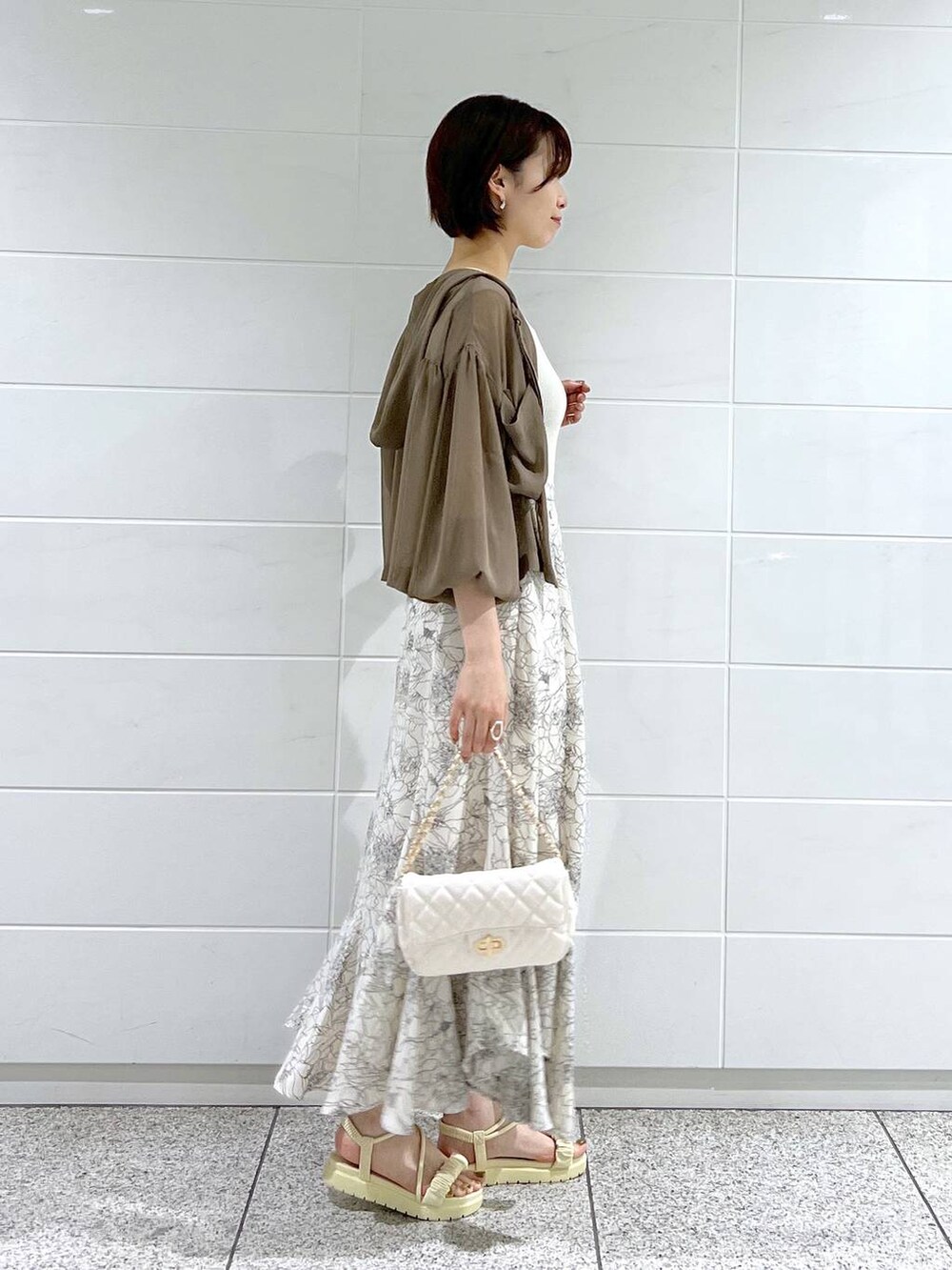 ホワイト系のサンダル、ホワイト系のショルダーバッグ、ブラウン系のパーカーを着用したレディースの夏コーディネートの2枚目の写真