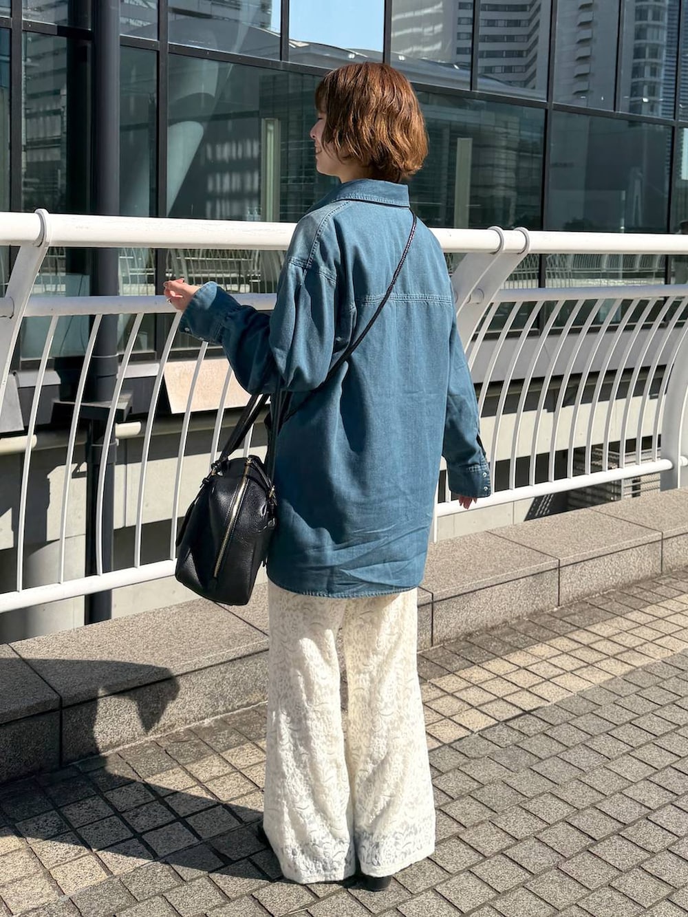 ブラック系のハンドバッグ、ブラック系のローファー、ホワイト系のその他パンツを着用したレディースの冬コーディネートの4枚目の写真