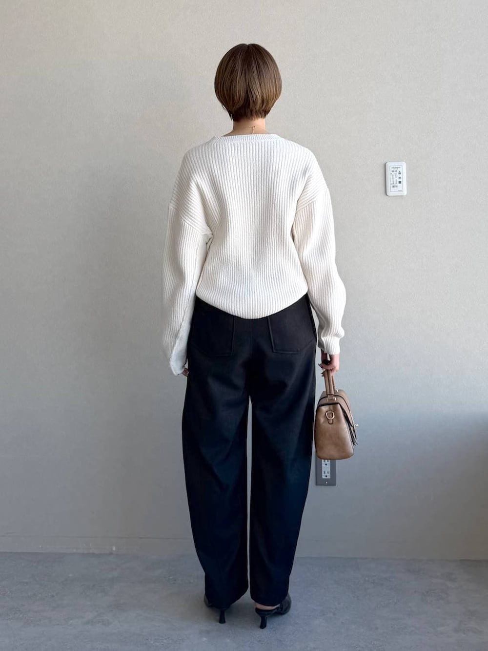 ブラック系のローファー、ブラウン系のショルダーバッグ、ホワイト系のニット/セーターを着用したレディースの冬コーディネートの3枚目の写真