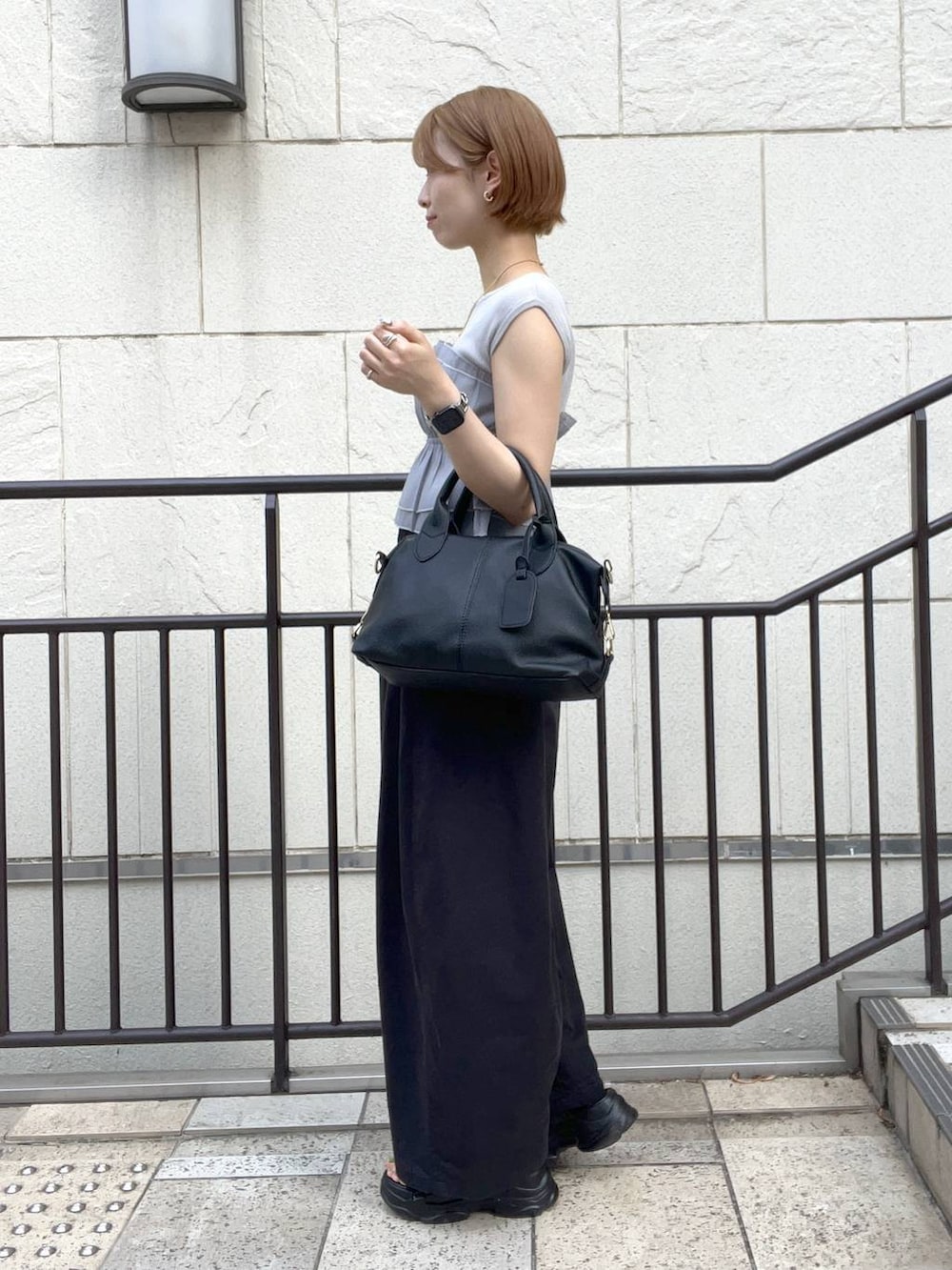 ブラック系のサンダル、ブラック系のその他パンツ、ブラック系のボストンバッグを着用したレディースの夏コーディネートの2枚目の写真