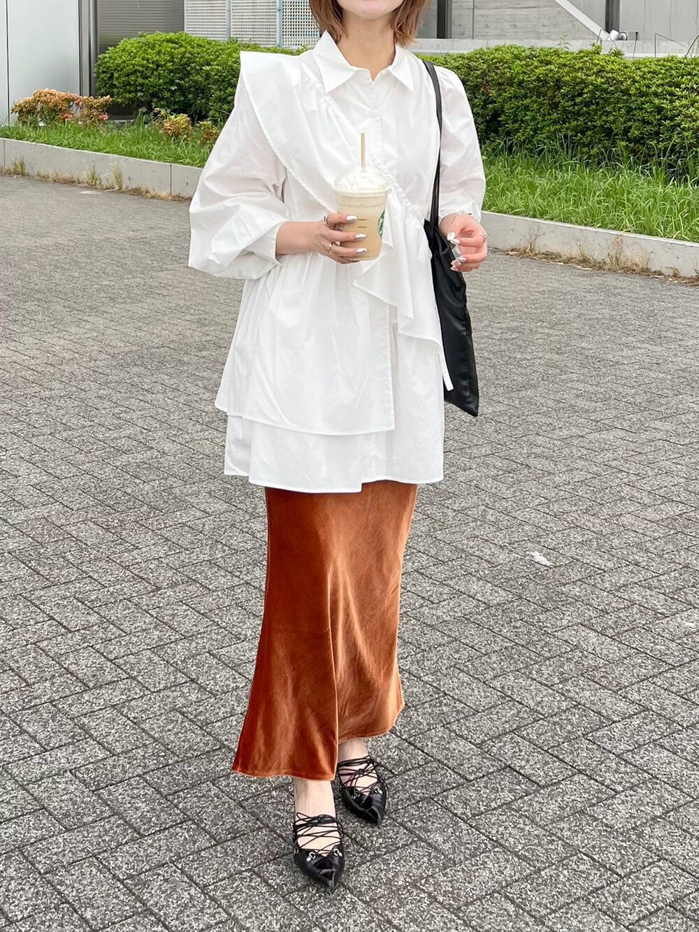 ホワイト系のシャツ/ブラウス、オレンジ系のスカートを着用したレディースの秋コーディネートの4枚目の写真