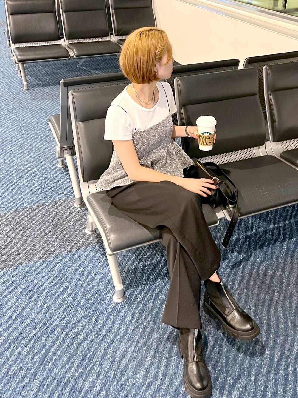 ブラック系のショルダーバッグ、グレー系のキャミソール、ブラック系のスラックスを着用したレディースの秋コーディネートの4枚目の写真