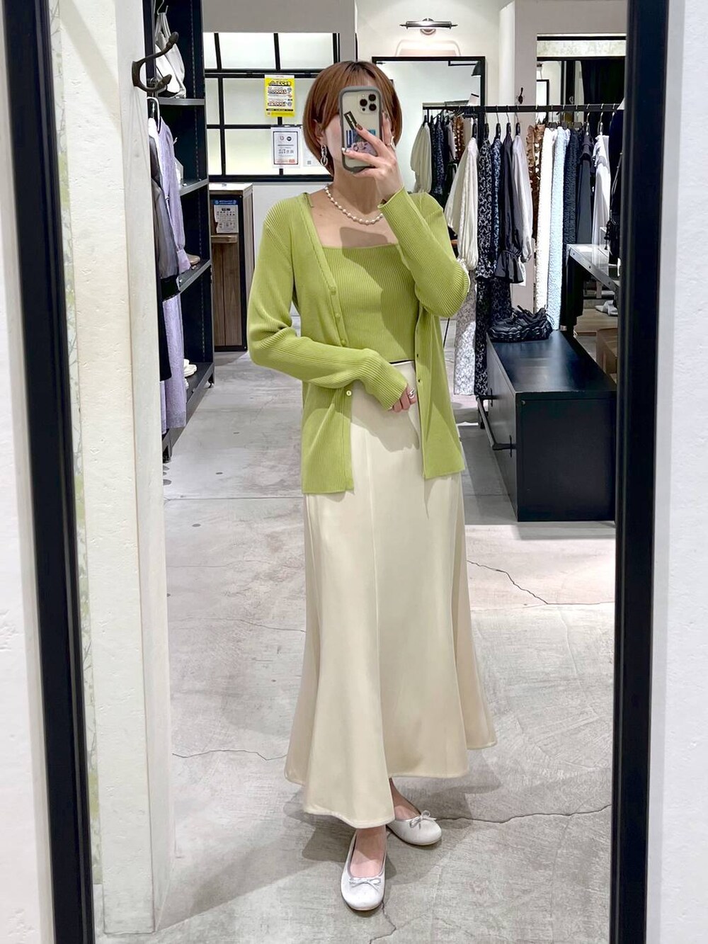 ベージュ系のスカート、シルバー系のバレエシューズ、グリーン系のカーディガン/ボレロを着用したレディースの春コーディネートの6枚目の写真