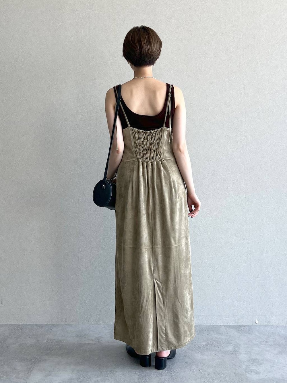 ベージュ系のワンピース、ブラック系のショルダーバッグ、ブラック系のスリッポンを着用したレディースの秋コーディネートの3枚目の写真