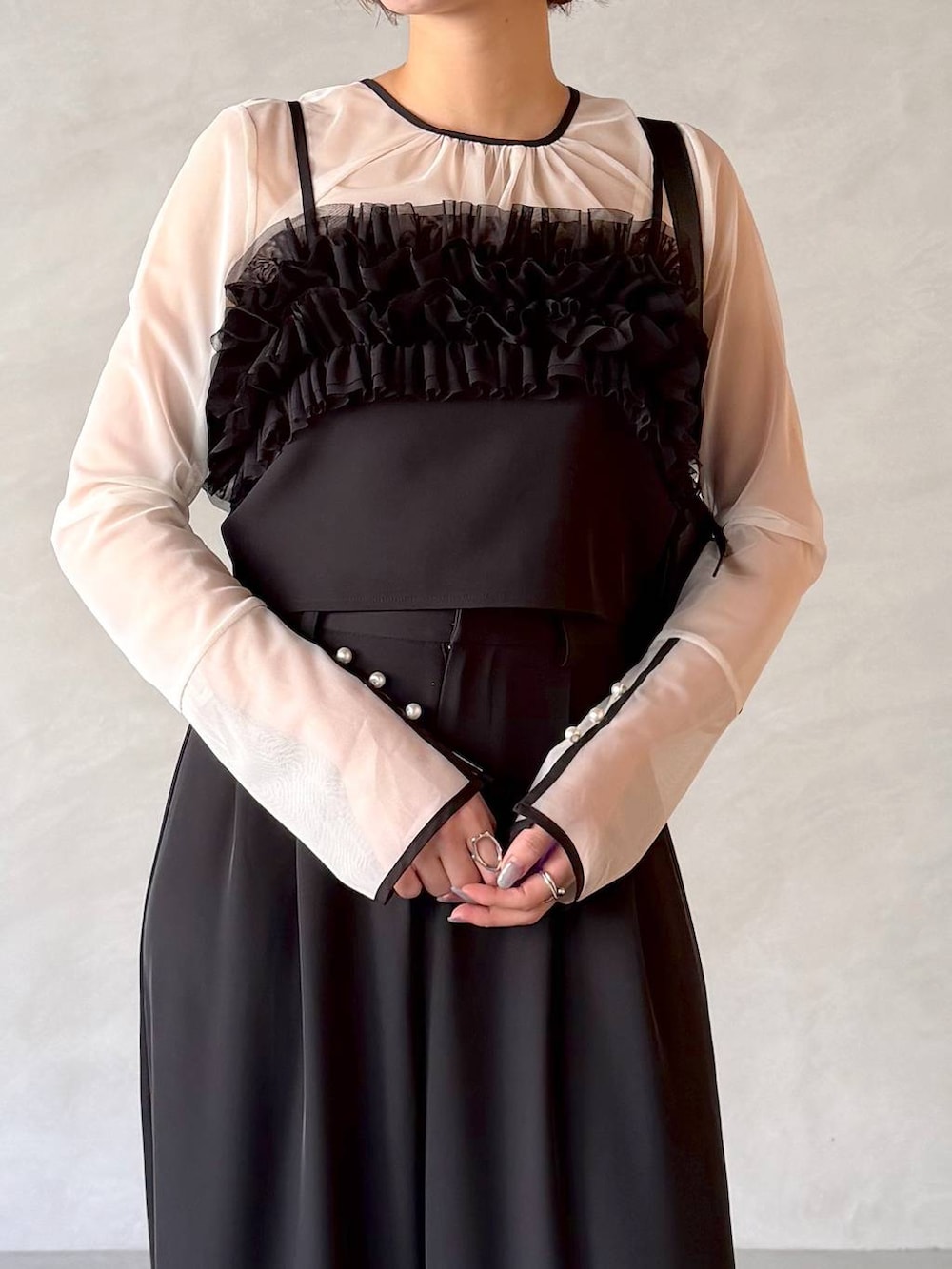 ブラック系のサンダル、ブラック系のショルダーバッグ、ブラック系のパンツドレスを着用したレディースの春コーディネートの4枚目の写真