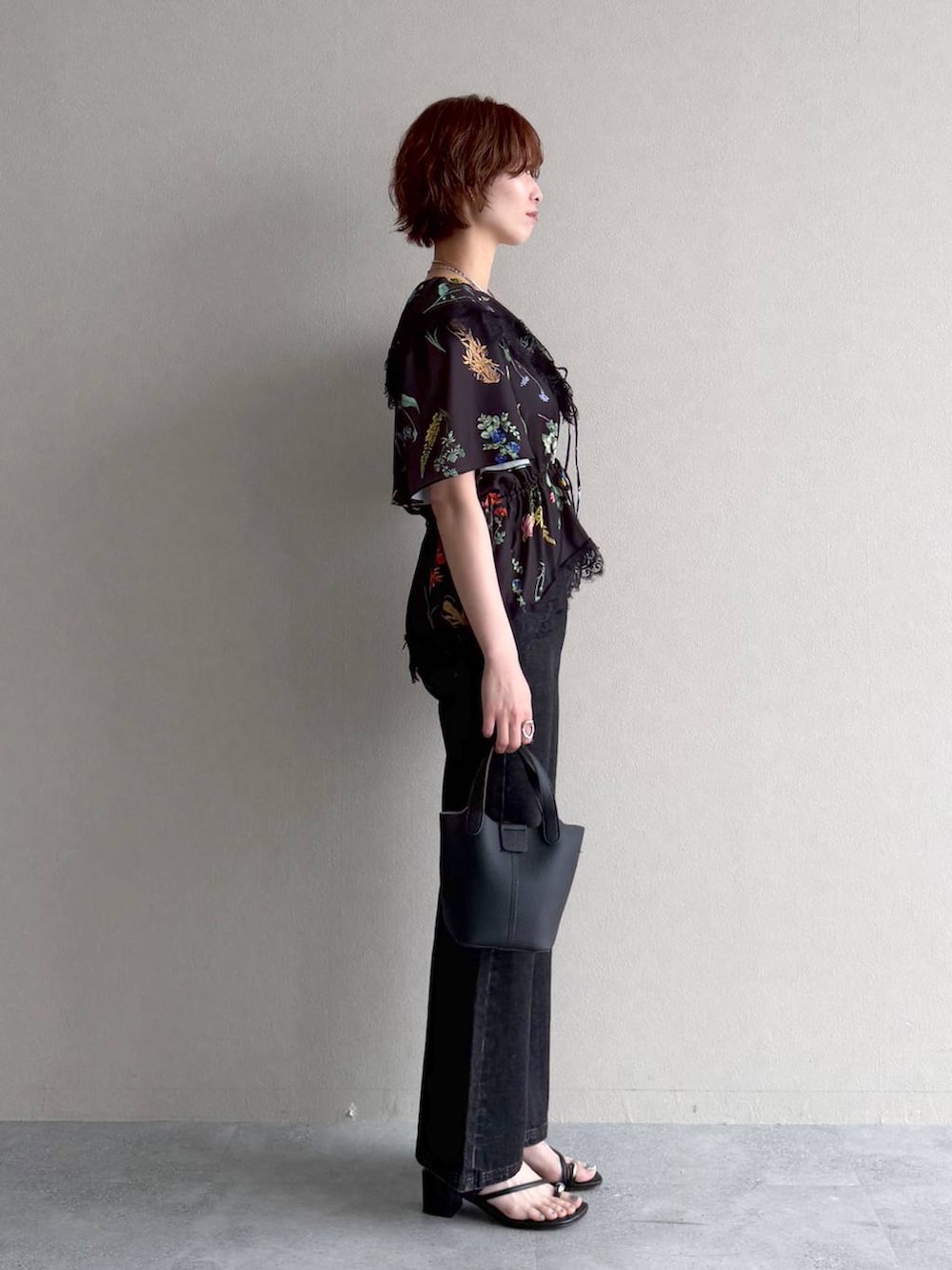 ブラック系のデニムパンツ、ブラック系のショルダーバッグ、ブラック系のシャツ/ブラウスを着用したレディースの春コーディネートの2枚目の写真