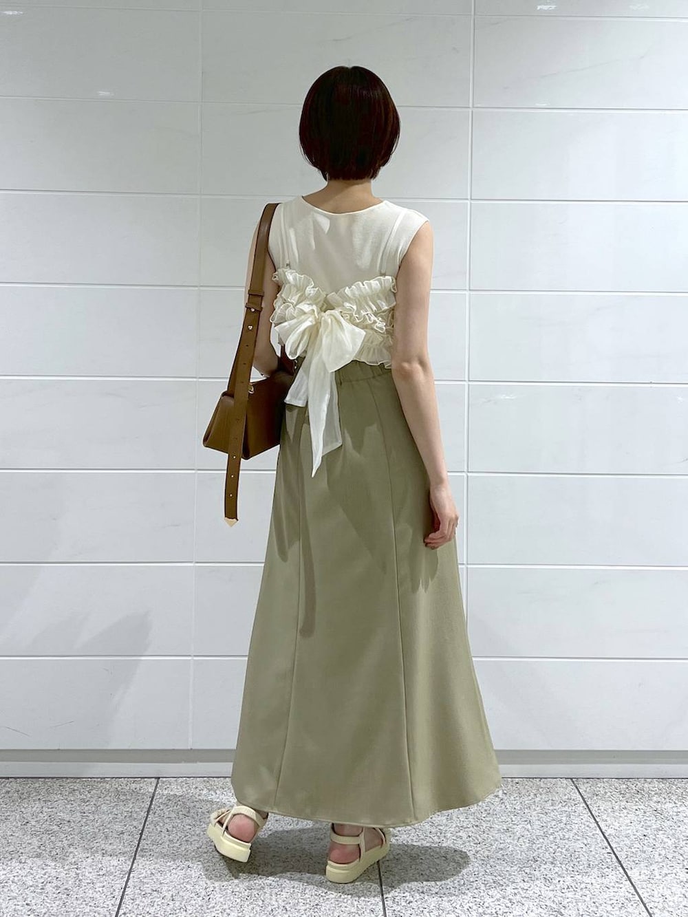 ホワイト系のサンダル、グリーン系のスカート、ブラウン系のショルダーバッグを着用したレディースの夏コーディネートの3枚目の写真