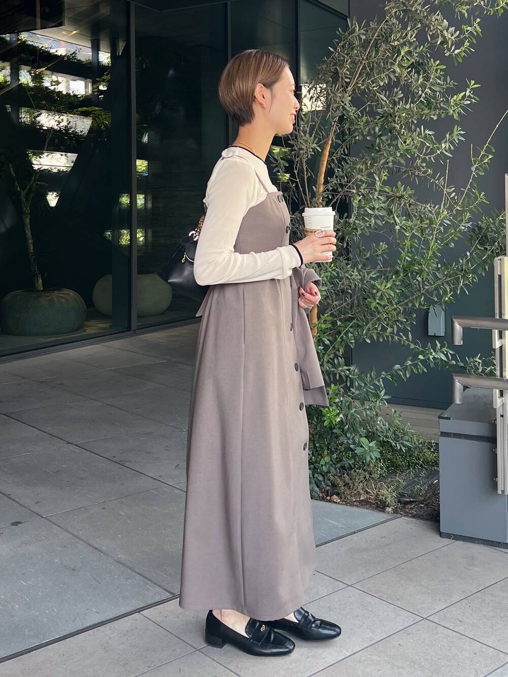 ホワイト系のTシャツ/カットソー、ブラック系のローファー、ベージュ系のワンピースを着用したレディースの秋コーディネートの5枚目の写真