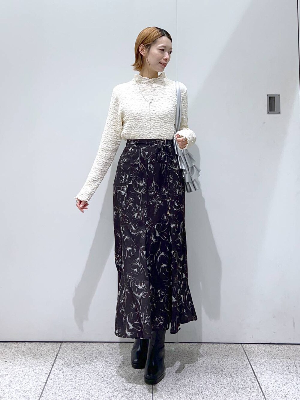 ブラック系のブーツ、ピンク系のカーディガン/ボレロ、シルバー系のトートバッグを着用したレディースの冬コーディネートの4枚目の写真