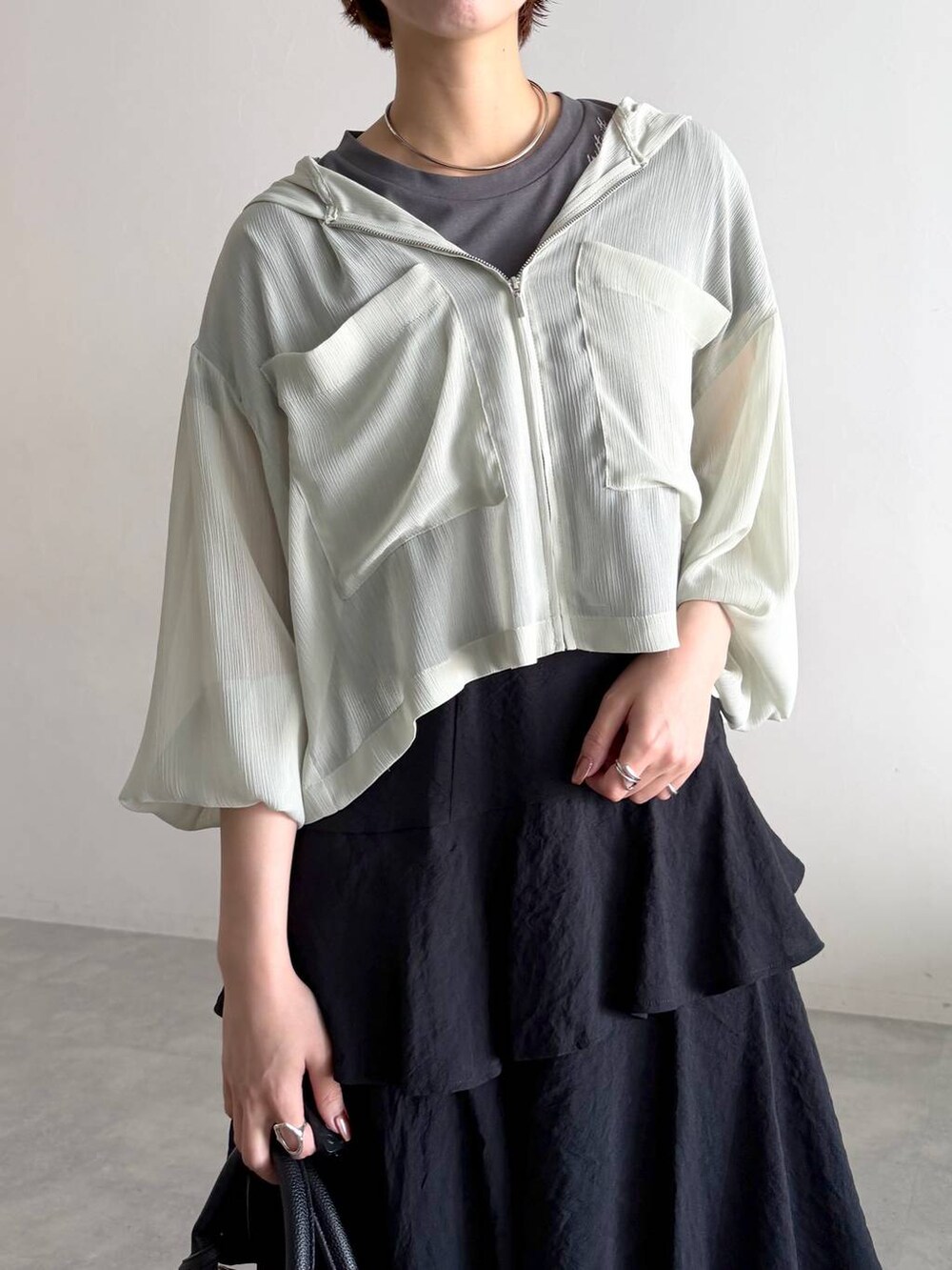 グレー系のTシャツ/カットソー、グリーン系のパーカー、ブラック系のスカートを着用したレディースの夏コーディネートの8枚目の写真