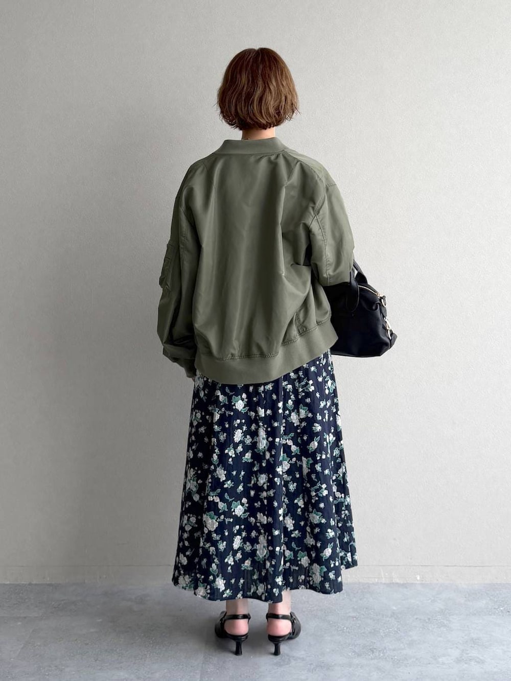 ブラック系のボストンバッグ、ブラック系のサンダル、グリーン系のMA-1を着用したレディースの春コーディネートの3枚目の写真