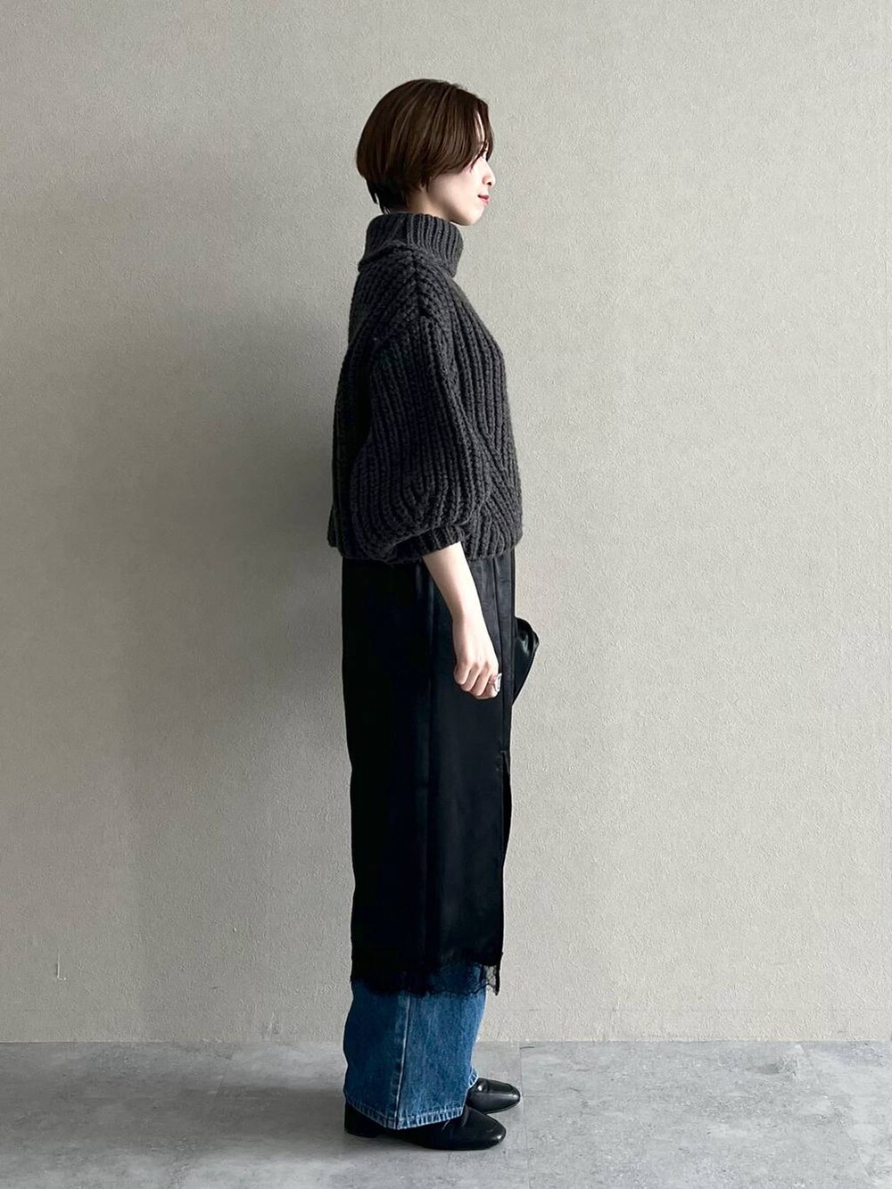 ブルー系のデニムパンツ、ブラック系のローファー、グレー系のニット/セーターを着用したレディースの秋コーディネートの2枚目の写真