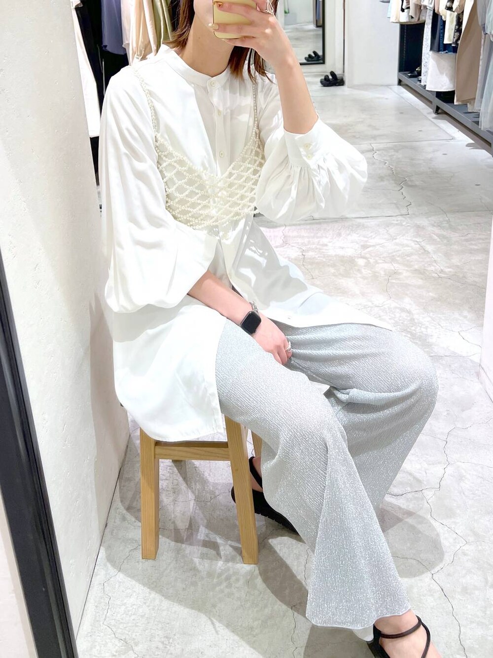 ホワイト系のシャツ/ブラウス、ホワイト系のベスト、ブラック系のサンダルを着用したレディースの春コーディネートの5枚目の写真