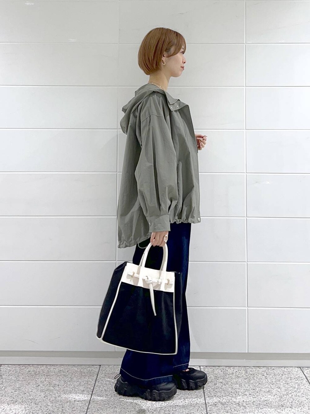 ブラック系のトートバッグ、グリーン系のマウンテンパーカー、ブラック系のバレエシューズを着用したレディースの春コーディネートの2枚目の写真