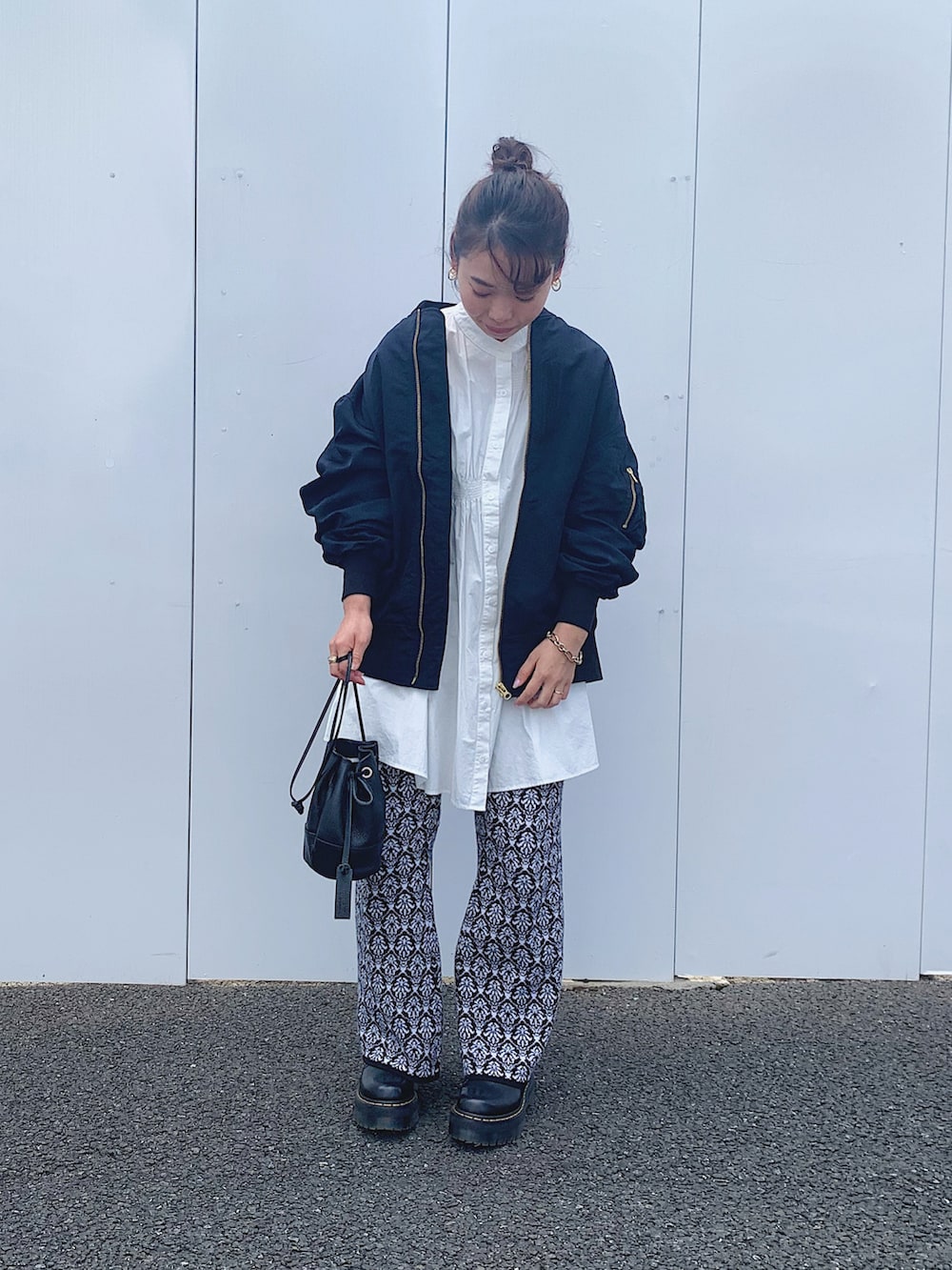 ブラック系のショルダーバッグ、ブラック系のその他パンツ、ブルー系のMA-1を着用したレディースの春コーディネートの2枚目の写真