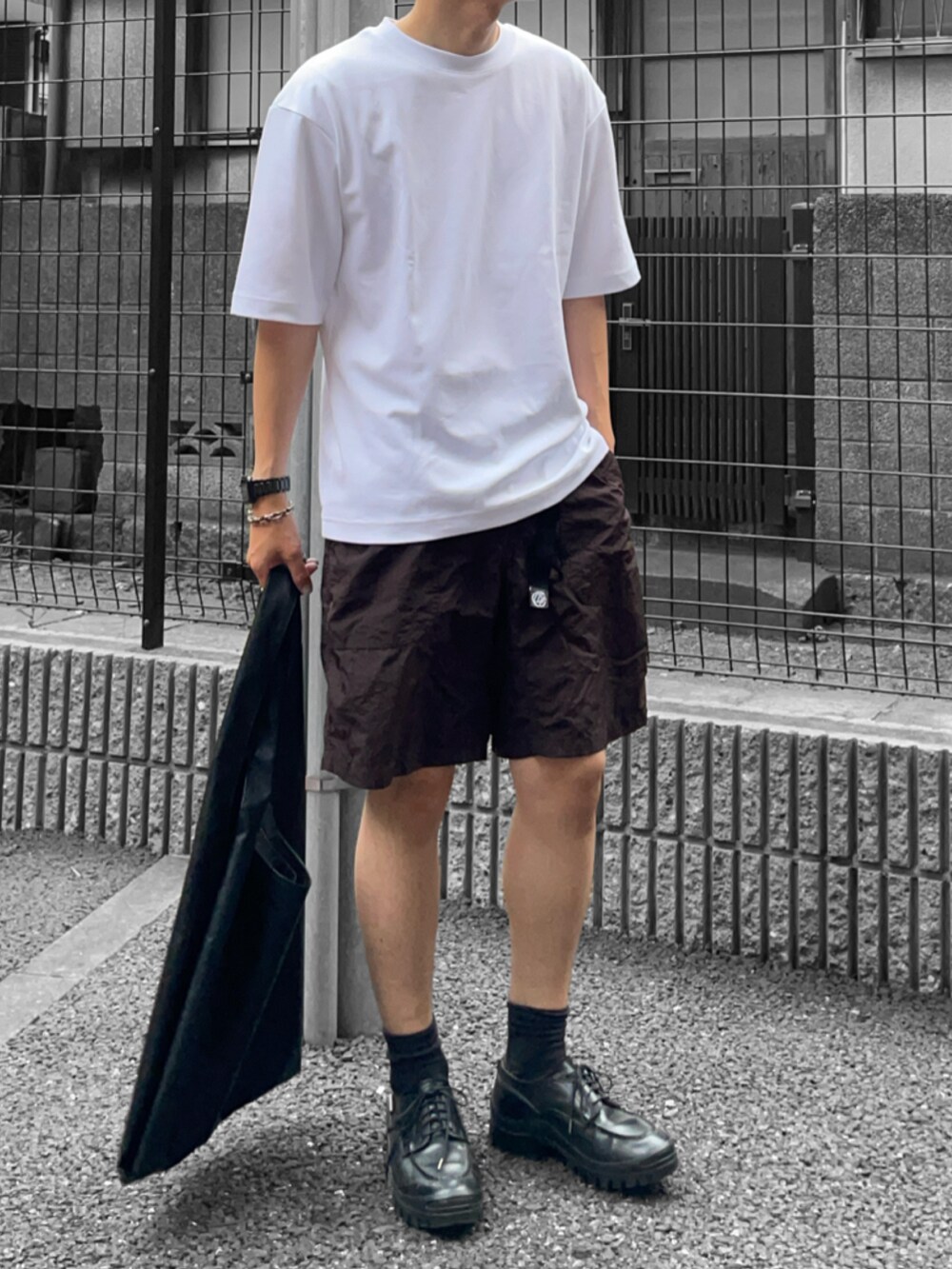 ホワイト系のTシャツ/カットソー、ブラック系のトートバッグ、ブラック系のその他シューズを着用したメンズの夏コーディネートの2枚目の写真