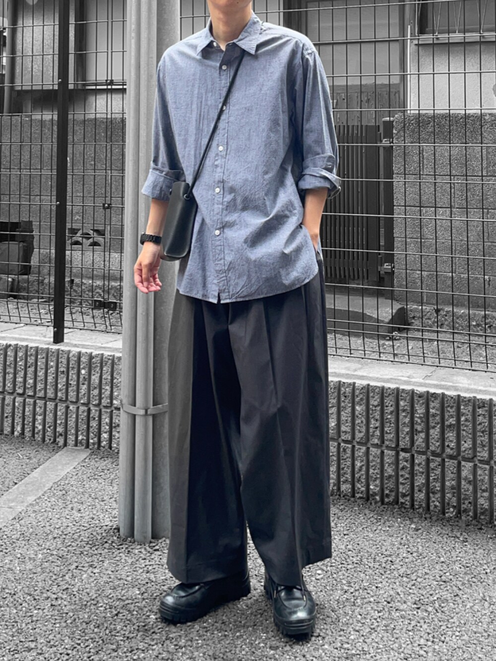 ブラック系のシャツ/ブラウス、グレー系のスラックス、ブラック系のローファーを着用したメンズの夏コーディネートの2枚目の写真