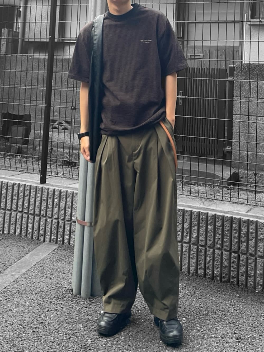 ブラウン系のTシャツ/カットソー、グリーン系のその他パンツ、ブラック系のトートバッグを着用したメンズの夏コーディネートの2枚目の写真