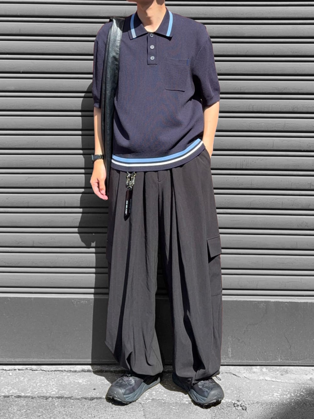 ブラック系のカーゴパンツ、ブラック系のトートバッグ、ブラック系のサンダルを着用したメンズの夏コーディネートの2枚目の写真