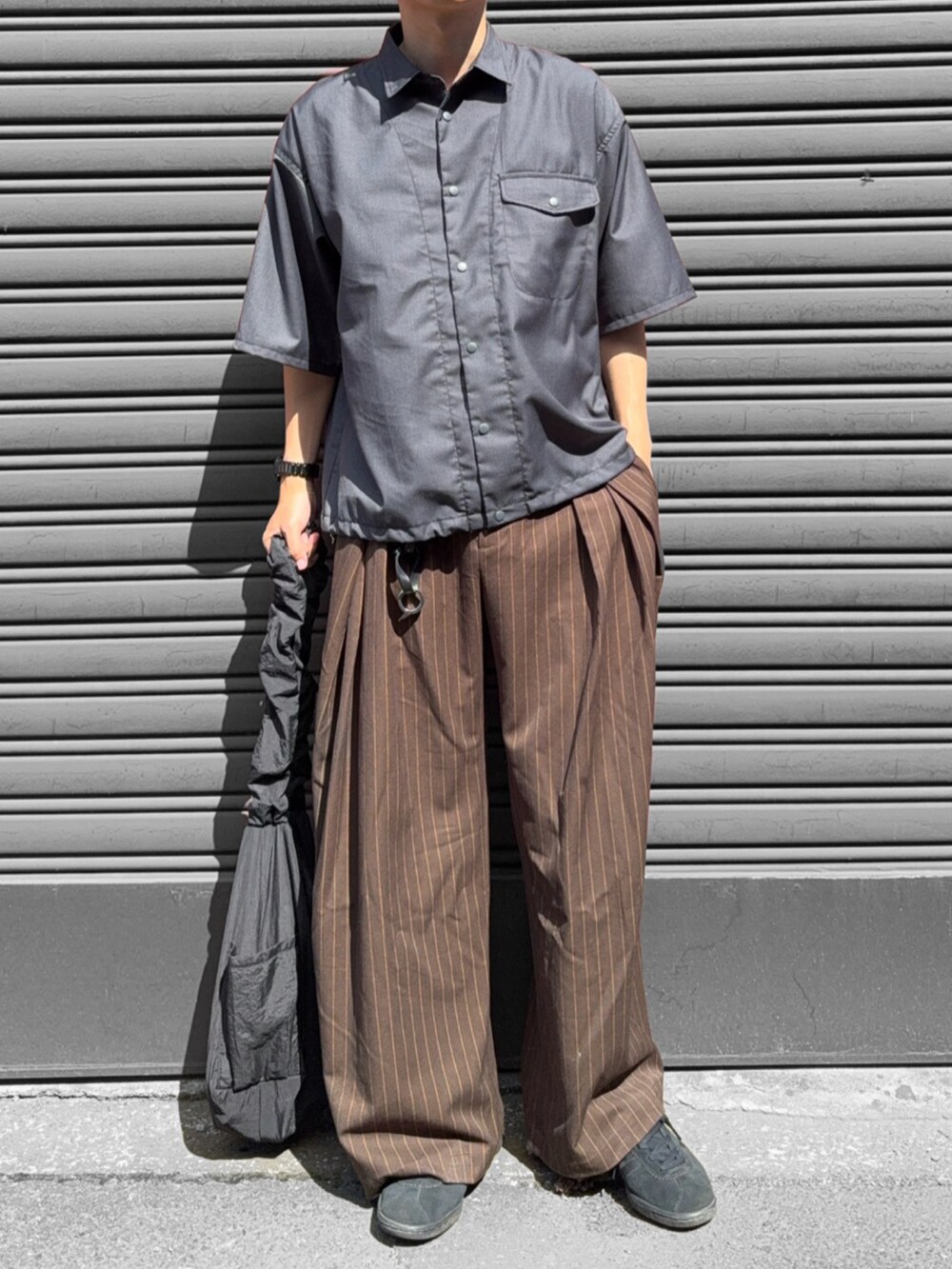 グレー系のシャツ/ブラウス、ブラック系のショルダーバッグ、ブラウン系のスラックスを着用したメンズの夏コーディネートの2枚目の写真