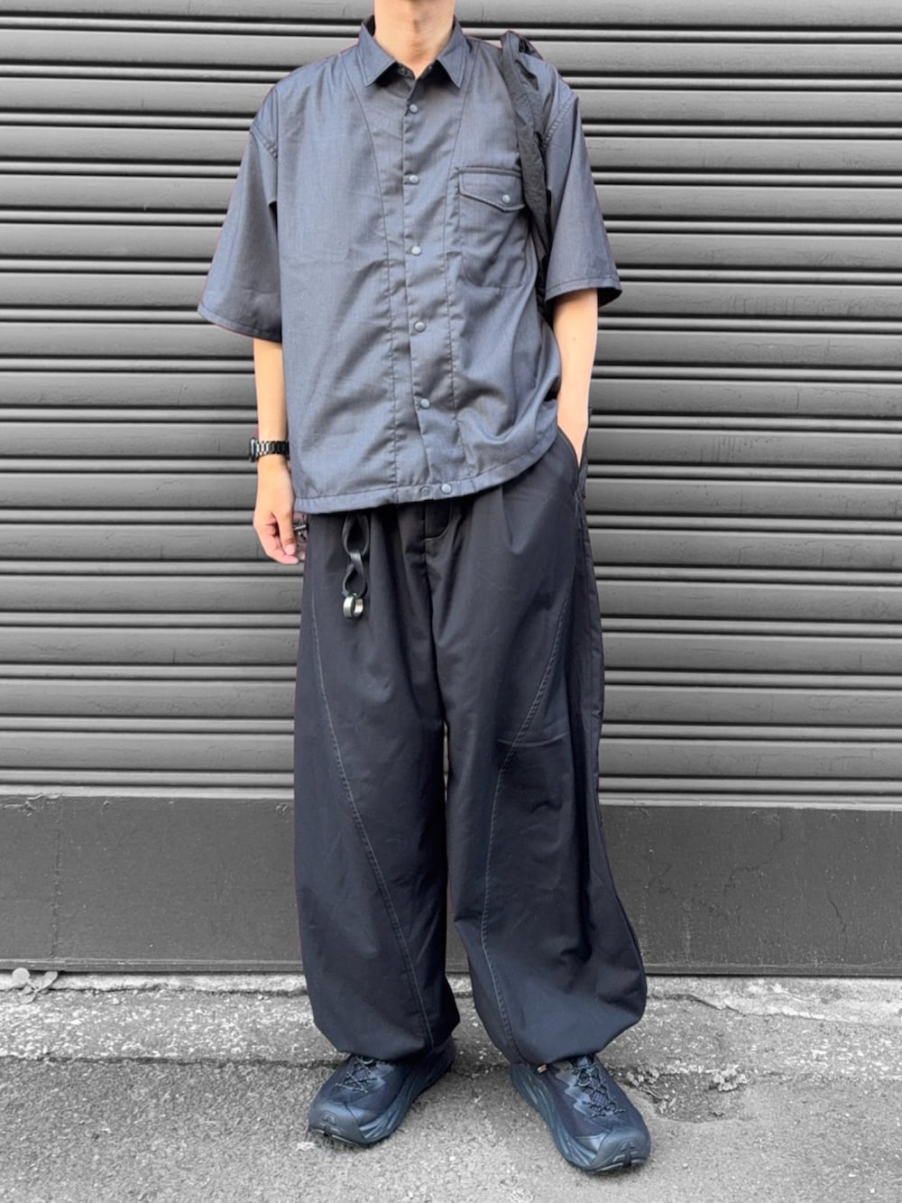 グレー系のシャツ/ブラウス、ブラック系のスラックス、ブラック系のショルダーバッグを着用したメンズの夏コーディネートの2枚目の写真