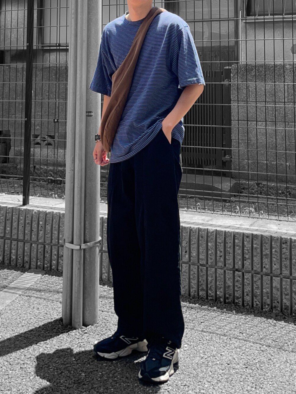 ブルー系のTシャツ/カットソー、ブラウン系のバッグ、ブラック系のデニムパンツを着用したメンズの夏コーディネートの2枚目の写真