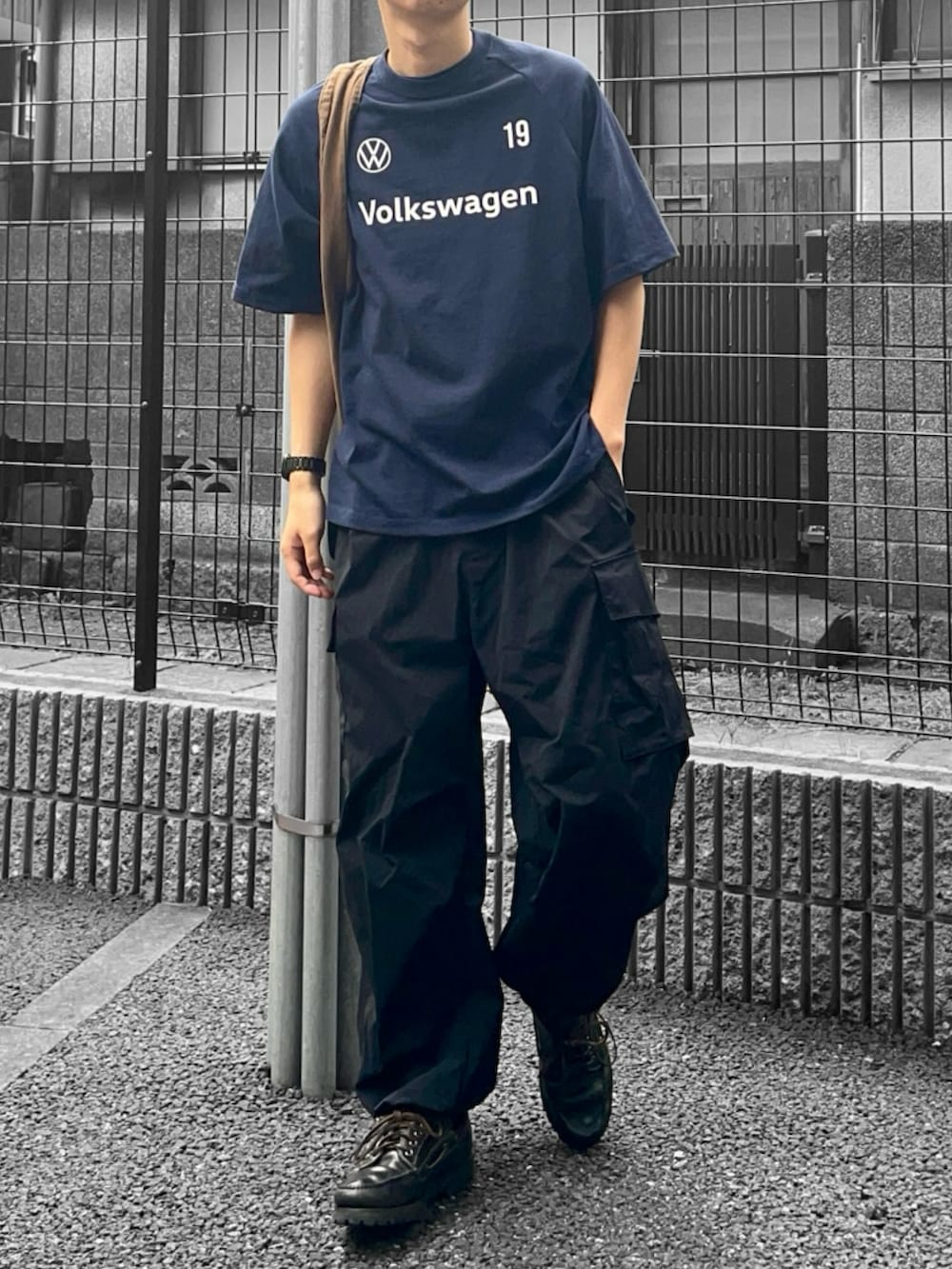 ブルー系のTシャツ/カットソー、ブラウン系のバッグ、ブラック系のカーゴパンツを着用したメンズの夏コーディネートの2枚目の写真