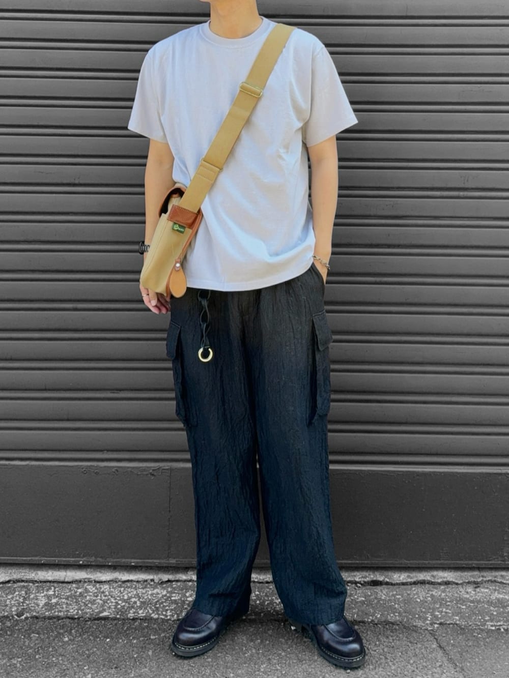 ベージュ系のショルダーバッグ、ブラウン系のモカシン/デッキシューズ、ベージュ系のTシャツ/カットソーを着用したメンズの秋コーディネートの2枚目の写真