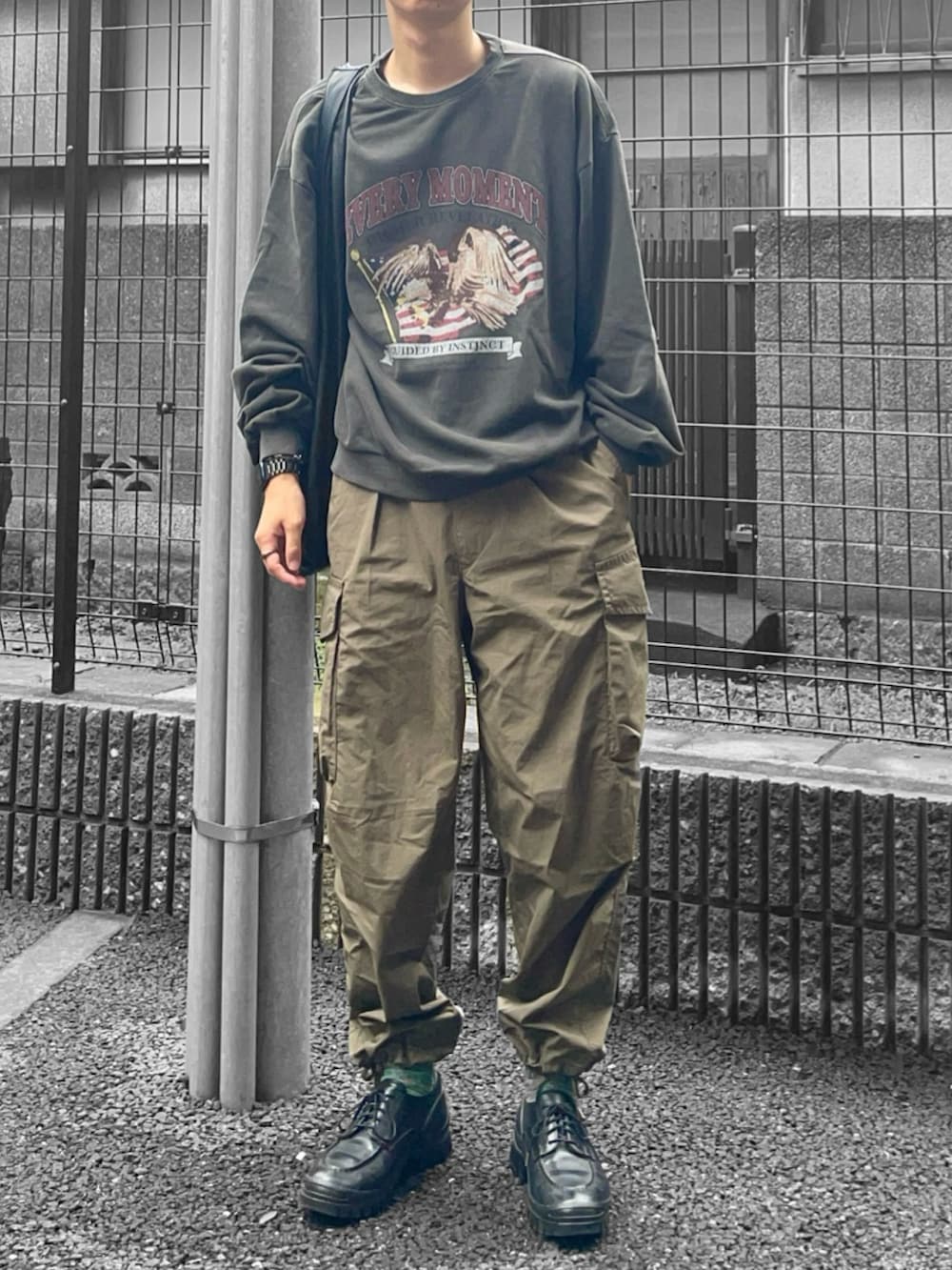 ブラック系のスウェット、ブラック系のトートバッグ、グリーン系のカーゴパンツを着用したメンズの夏コーディネートの2枚目の写真