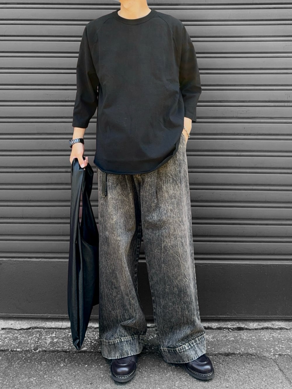 ブラウン系のモカシン/デッキシューズ、ブラック系のトートバッグ、ブラック系のデニムパンツを着用したメンズの秋コーディネートの2枚目の写真