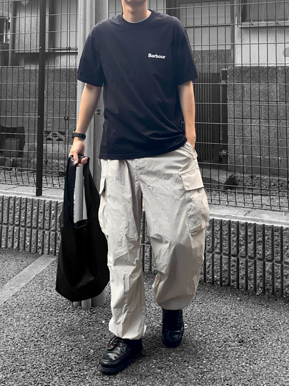 ブラック系のTシャツ/カットソー、ブラック系のトートバッグ、グレー系のカーゴパンツを着用したメンズの夏コーディネートの2枚目の写真