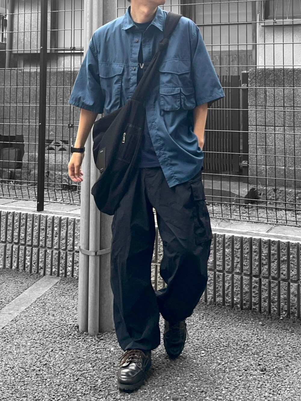 ブルー系のシャツ/ブラウス、ブラック系のモカシン/デッキシューズ、ブラック系のカーゴパンツを着用したメンズの夏コーディネートの2枚目の写真