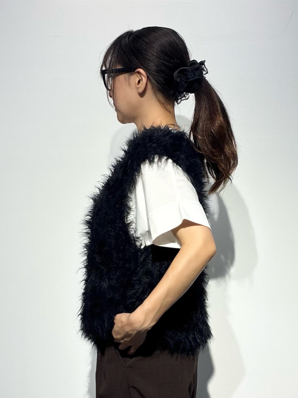 ベージュ系のその他パンツ、ブラウン系のショルダーバッグ、ブラック系のベストを着用したレディースの夏コーディネートの5枚目の写真