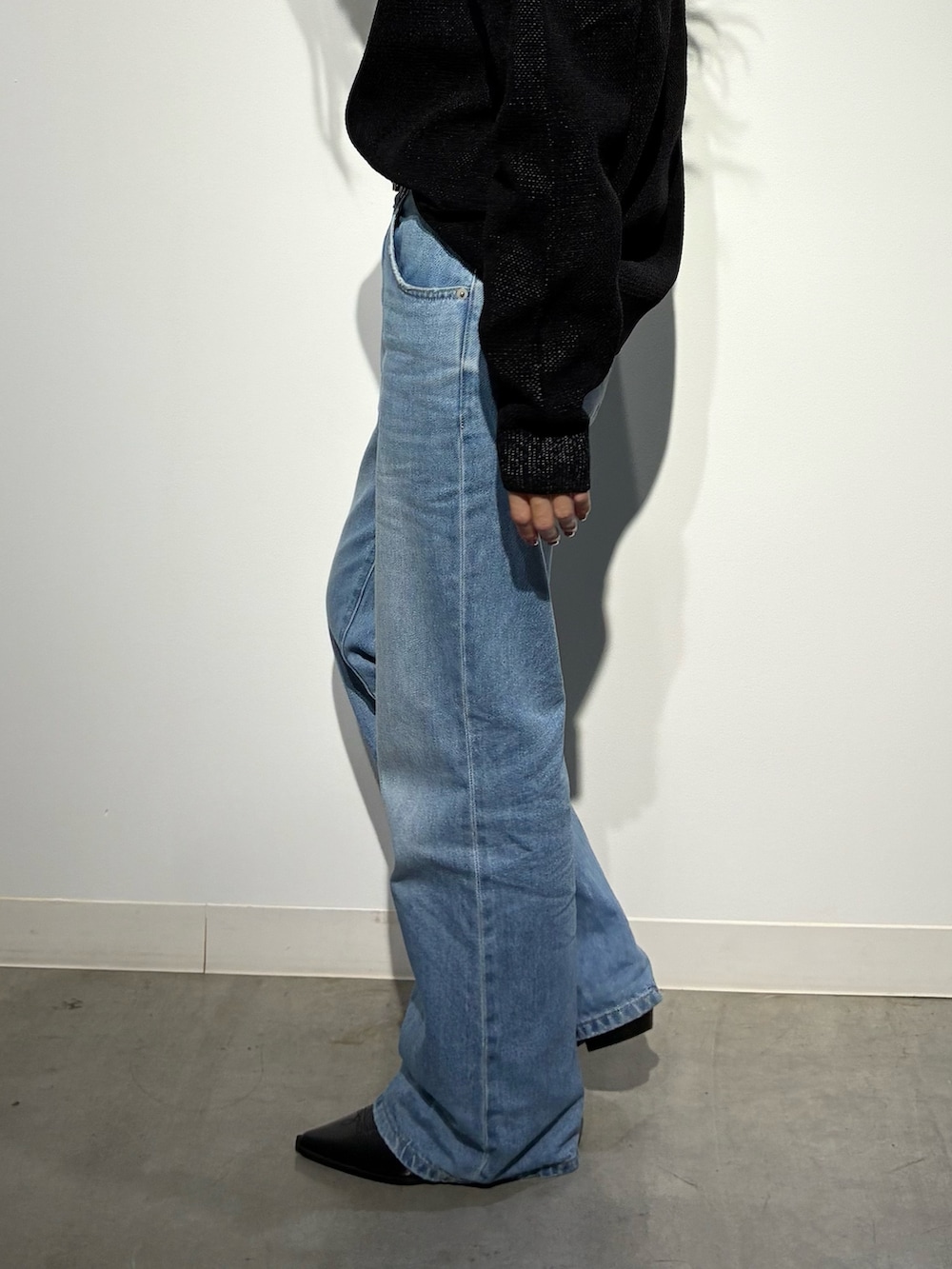 ブラック系のパンプス、ブルー系のデニムパンツ、ブラウン系のショルダーバッグを着用したレディースの秋コーディネートの8枚目の写真