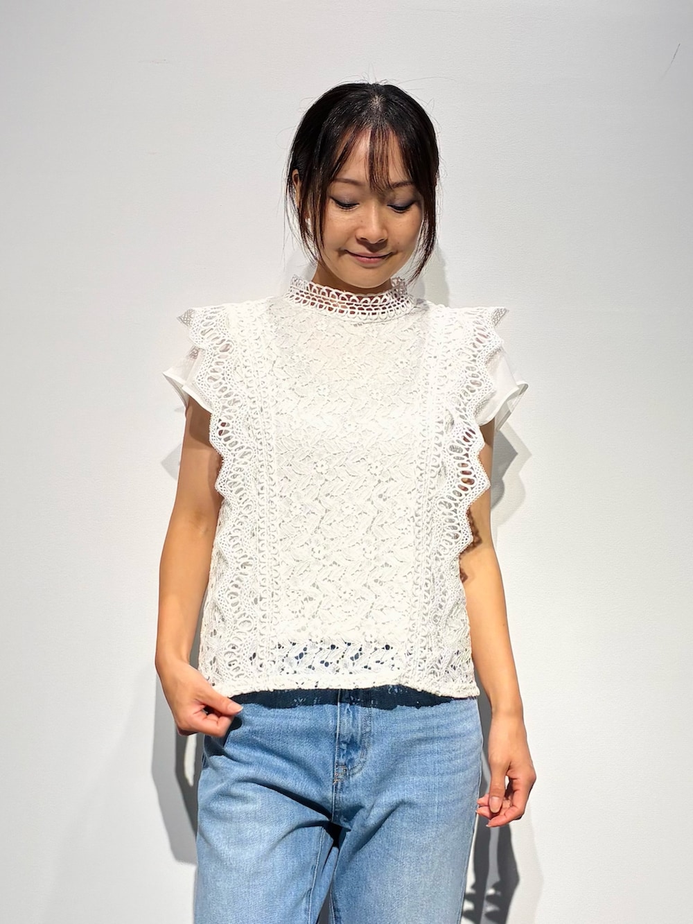 グレー系のデニムパンツ、ベージュ系のトートバッグ、ホワイト系のトップスを着用したレディースの夏コーディネートの5枚目の写真