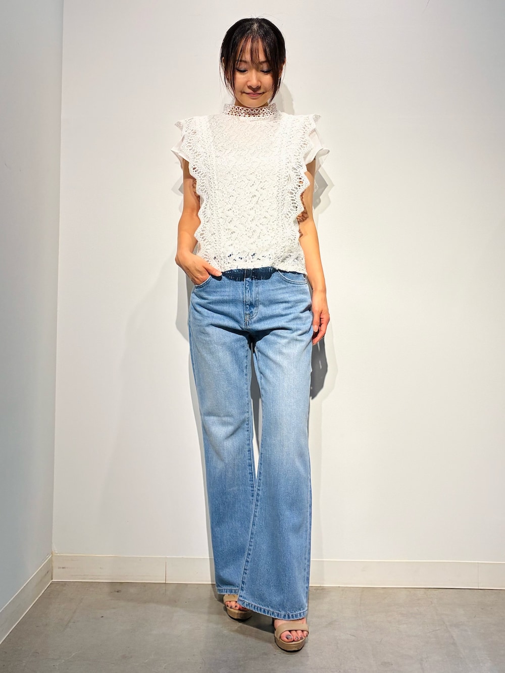 グレー系のデニムパンツ、ベージュ系のトートバッグ、ホワイト系のトップスを着用したレディースの夏コーディネートの2枚目の写真
