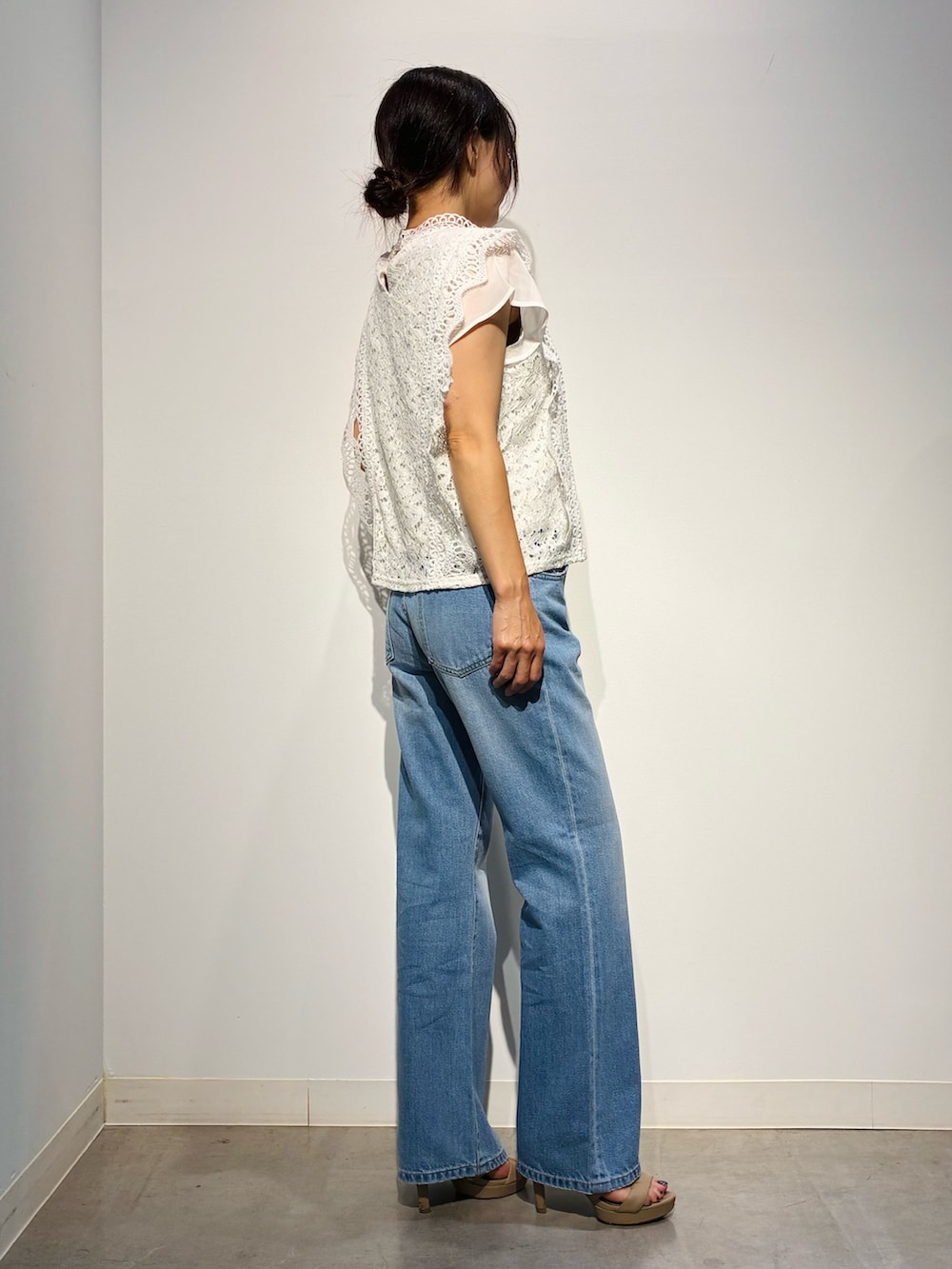 グレー系のデニムパンツ、ベージュ系のトートバッグ、ホワイト系のトップスを着用したレディースの夏コーディネートの3枚目の写真