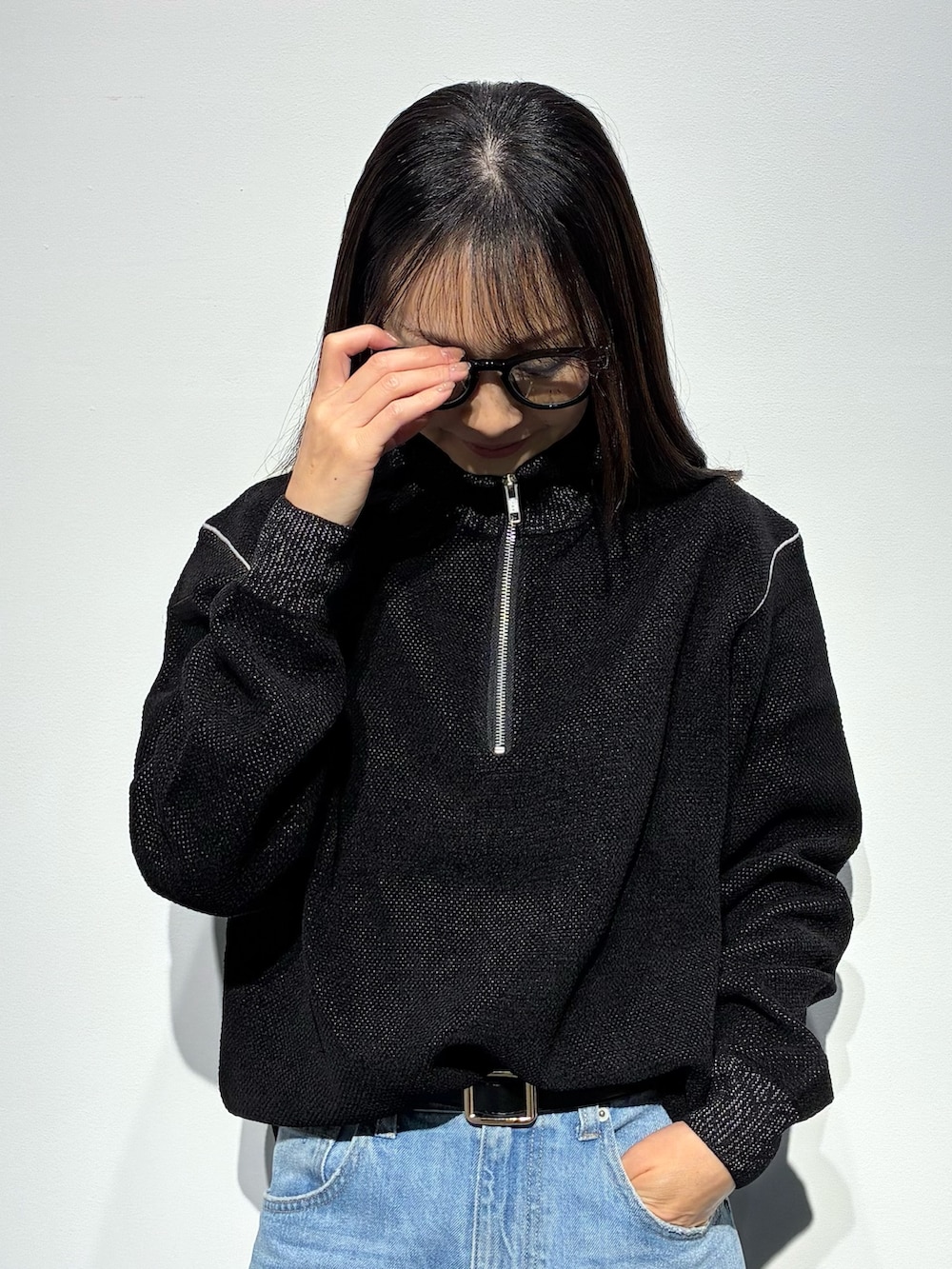 ブラック系のパンプス、ブルー系のデニムパンツ、ブラウン系のショルダーバッグを着用したレディースの秋コーディネートの4枚目の写真