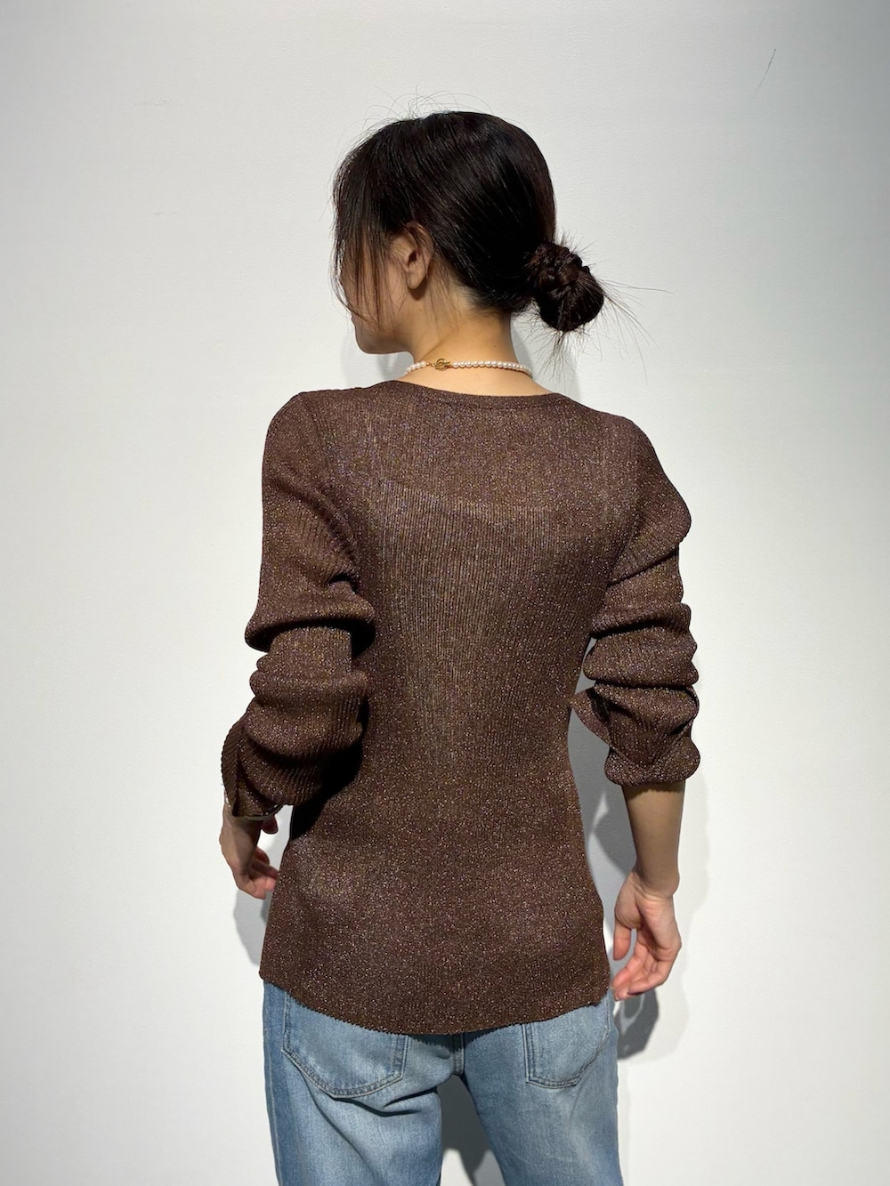 ブラウン系のニット/セーター、ホワイト系のTシャツ/カットソー、ブラウン系のショルダーバッグを着用したレディースの夏コーディネートの4枚目の写真