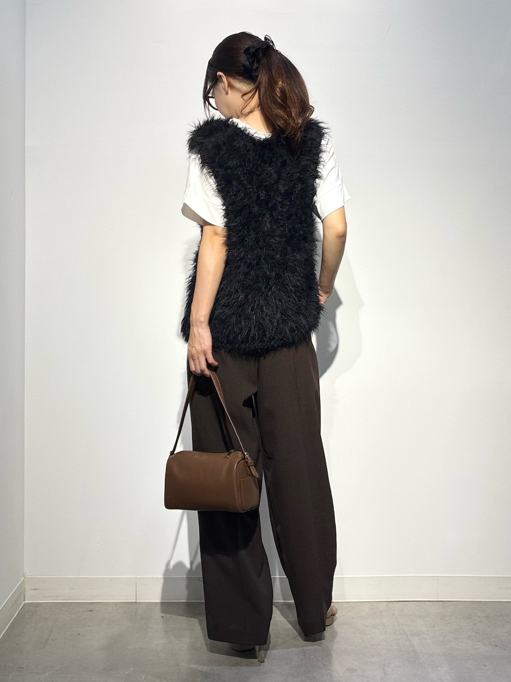 ベージュ系のその他パンツ、ブラウン系のショルダーバッグ、ブラック系のベストを着用したレディースの夏コーディネートの3枚目の写真