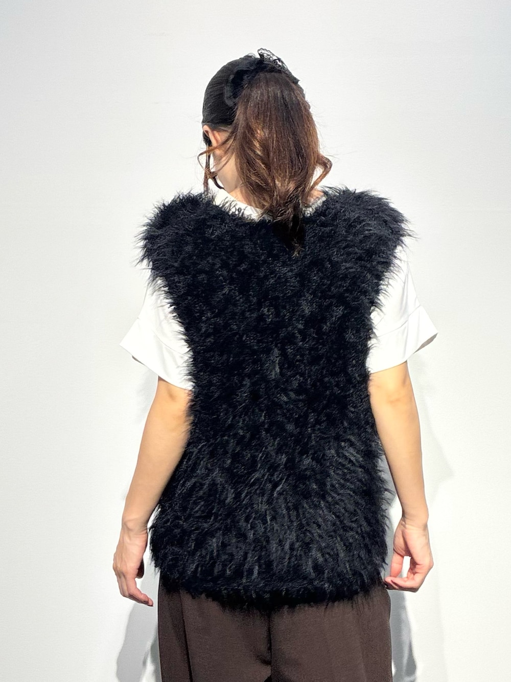 ベージュ系のその他パンツ、ブラウン系のショルダーバッグ、ブラック系のベストを着用したレディースの夏コーディネートの6枚目の写真